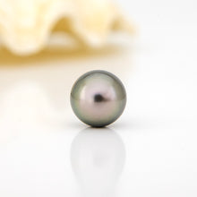 Load image into Gallery viewer, Single pearl on a reflective surface with a blurred background