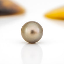 Load image into Gallery viewer, Single pearl on a reflective surface with blurred background