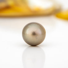 Load image into Gallery viewer, Single pearl on a reflective surface with a blurred background