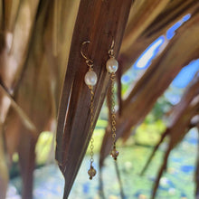 Load image into Gallery viewer, A pair of freshwater pearl drop earrings with glass bead detail, hanging from 14k gold fill metal hooks, displayed against a natural background.