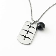 Load image into Gallery viewer, A silver-toned dog tag necklace featuring three engraved bird silhouettes, with a small black spherical bead charm on a white background.