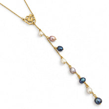 Load image into Gallery viewer, A gold-toned lariat-style necklace featuring a floral hibiscus pendant and a dangling chain with multiple small baroque pearls in white, lavender, and dark blue-gray, shown on a plain white background.