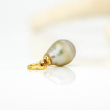 Load image into Gallery viewer, A single gold teardrop pendant featuring a lustrous, iridescent gray-green baroque pearl, resting on a clean white reflective surface.