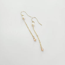 Load image into Gallery viewer, A pair of freshwater pearl drop earrings with glass bead detail, hanging from 14k gold fill metal hooks, displayed against a white background.
