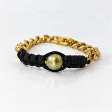 Load image into Gallery viewer, A gold chain bracelet with a black woven cord center and a round green pearl, shown on a clean white background.
