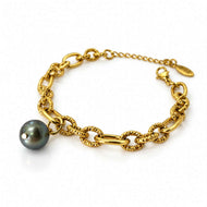 A gold chain bracelet featuring textured oval links and a single dark gray freshwater pearl pendant, displayed on a clean white background.