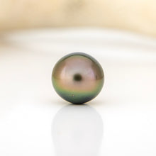 Load image into Gallery viewer, Single pearl on a white surface with a beige background
