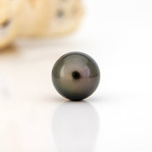 Load image into Gallery viewer, Single pearl on a reflective surface with a blurred background
