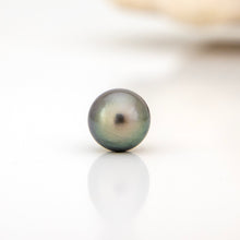 Load image into Gallery viewer, Single pearl on a reflective surface with a blurred background
