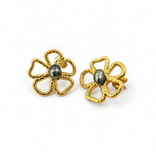 Load image into Gallery viewer, A pair of gold flower-shaped stud earrings with textured petals and a dark gray pearl center, shown on a plain white background.
