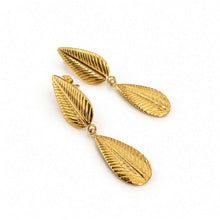 Load image into Gallery viewer, A pair of gold drop earrings designed as textured leaf drops, shown on a clean white background.
