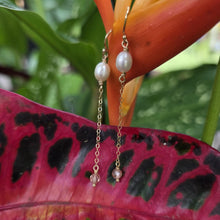 Load image into Gallery viewer, Pearl earrings hanging from a tropical leaf
