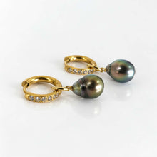 Load image into Gallery viewer, A pair of gold huggie hoop earrings with small clear pavé stones and dangling pearls, shown on a clean white background.
