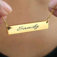 Load image into Gallery viewer, Gold necklace with a bar pendant engraved with 'Sandy' on a neutral background
