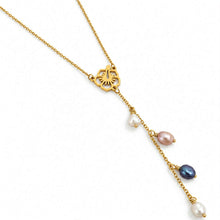 Load image into Gallery viewer, A gold-toned lariat-style necklace featuring a floral hibiscus pendant and a dangling chain with multiple small baroque pearls in white, lavender, and dark blue-gray, shown on a plain white background.
