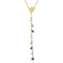 Load image into Gallery viewer, A gold-toned lariat-style necklace featuring a floral hibiscus pendant and a dangling chain with multiple small baroque pearls in white, lavender, and dark blue-gray, shown on a plain white background.
