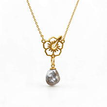 Load image into Gallery viewer, A gold chain necklace featuring a flower pendant with a keshi pearl, set against a plain white background.
