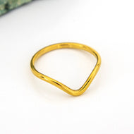 Gold ring with a wave design on a white background
