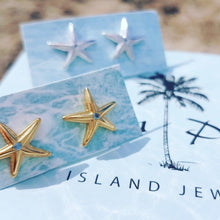 Load image into Gallery viewer, Starfish shaped earrings in gold and silver on place cards with blurred background
